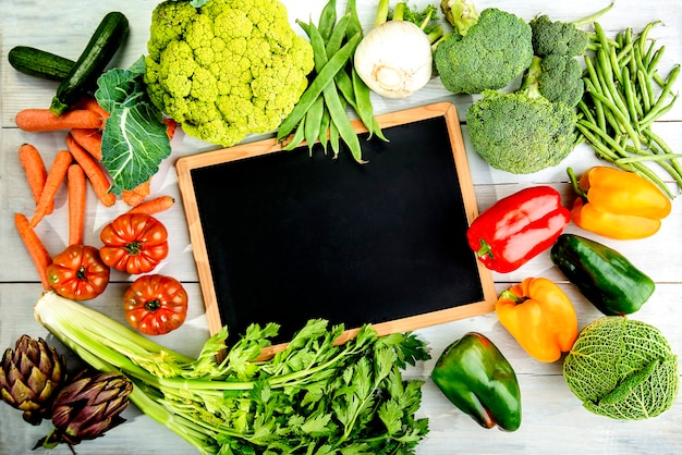 Composición de verduras de otoño con pizarra