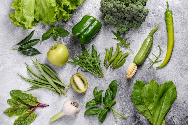 Composición de verduras verdes brillantes y jugosas cerca de especias y hierbas