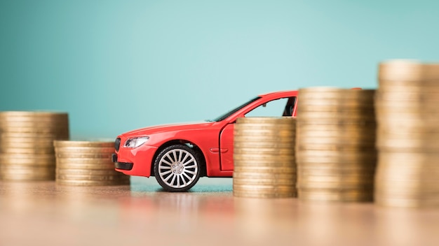 Foto composición de vista frontal de monedas con coche rojo