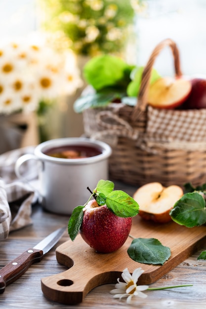 Compota caseira de maçãs de verão em uma mesa de madeira perto da janela