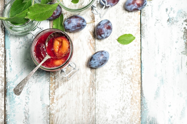 Compota de ameixas em fundo de madeira rústica. Geléia de frutas