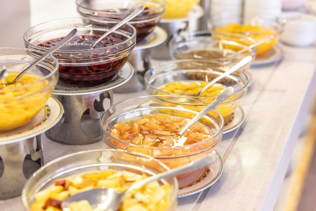 Compotas de frutas en tazones en las mesas de buffet en el restaurante del hotel