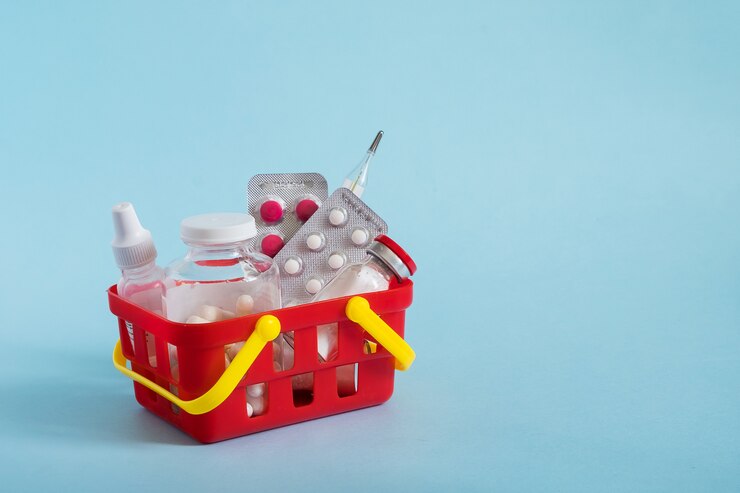 Compra e conceito de medicina compras on-line. Várias cápsulas, comprimidos e medicamento no cesto de compras em fundo azul.