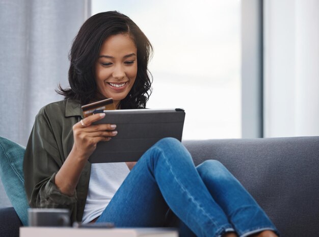 Compra con tarjeta de crédito o mujer feliz en tableta en el sofá para compras en línea comercio electrónico o pago en el sitio web Compra financiera o persona en pantalla táctil para renovación o decoración interior en el hogar