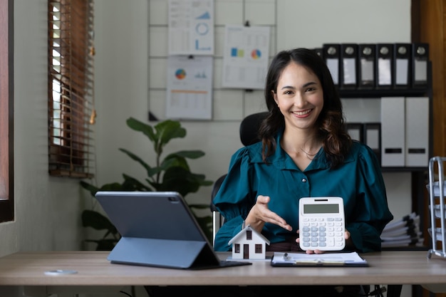 Compra y venta de casas y precios de bienes raíces concepto mujer usando calculadora para contar el dinero del alquiler o el costo del seguro del hogar Cálculo de préstamo hipotecario o inversión