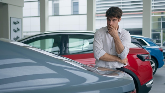 Comprador cliente hombre caucásico hombre de negocios en el servicio de alquiler de salón de automóviles elegir comprar coche tocando