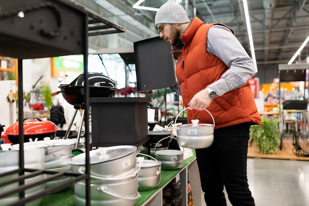 Foto el comprador elige una parrilla y una olla de picnic nuevas