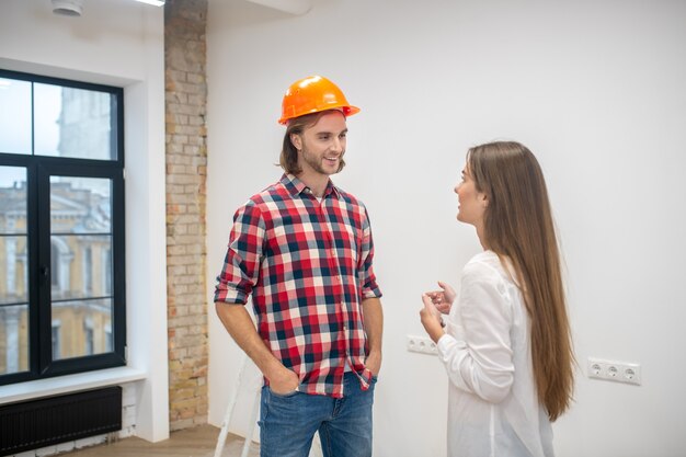 Comprador femenino hablando con el trabajador de la construcción