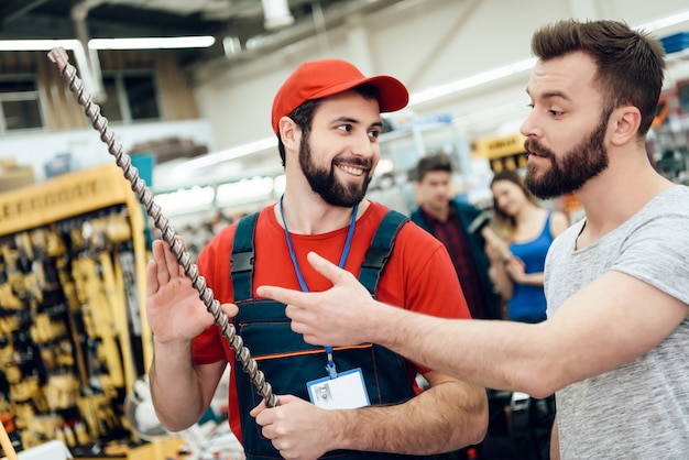 El comprador hace preguntas al vendedor sobre el taladro gigante.