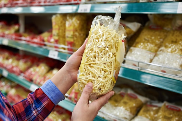 Comprador con un paquete de pasta en la tienda.