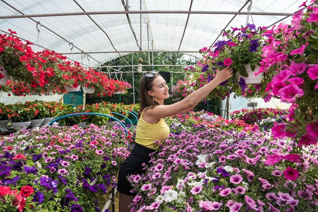 Foto compradora elige hermosas flores en un invernadero