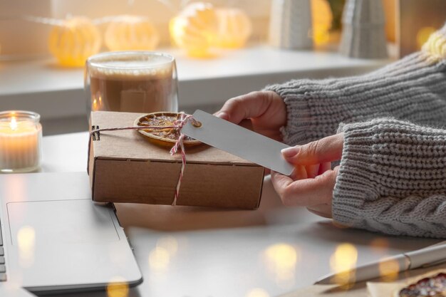 Foto compradora feminina faz pedidos em laptop mulher escolhendo presentes on-line compras em casa aconchegante entre caixas de presentes e pacotes vendas de inverno sexta-feira negra promoções de desconto de natal luz bokeh desfocada