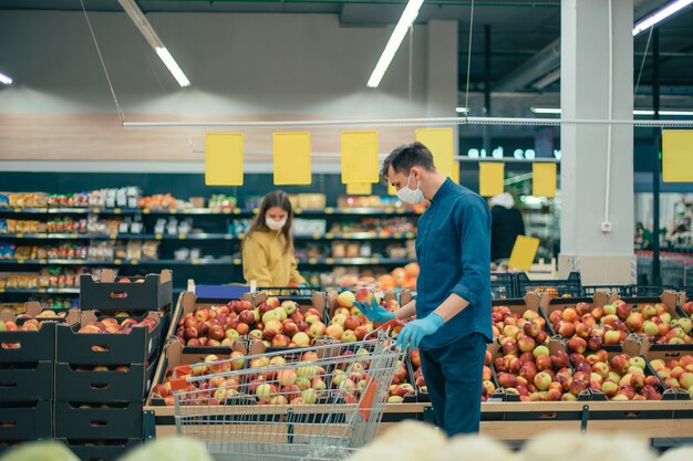 Compradores con máscaras protectoras de pie en un supermercado a una distancia segura. foto con copia del espacio