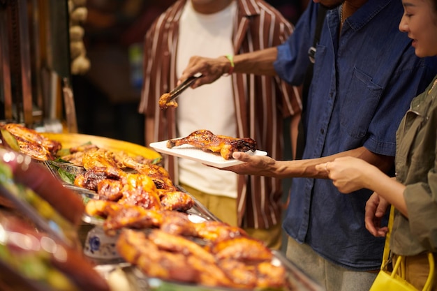 Foto comprando pollo frito en el mercado de alimentos