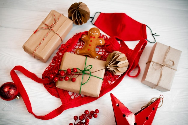 Comprando presentes e embrulhando em papel artesanal antes do Natal Homem-biscoito feito de feltro em um saco vermelho