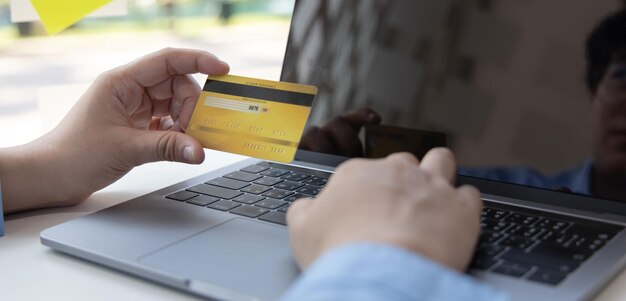 Comprar productos en línea Empresario que utiliza un portátil registra a través de tarjetas de crédito para hacer compras en línea