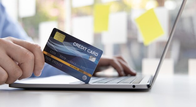Comprar productos en línea Empresario que utiliza un portátil registra a través de tarjetas de crédito para hacer compras en línea