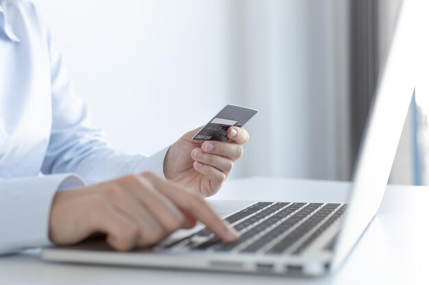 Comprar productos en línea Empresario que utiliza un portátil registra a través de tarjetas de crédito para hacer compras en línea