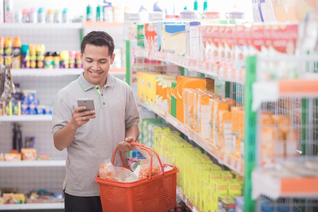 Compras asiáticas masculinas no supermercado