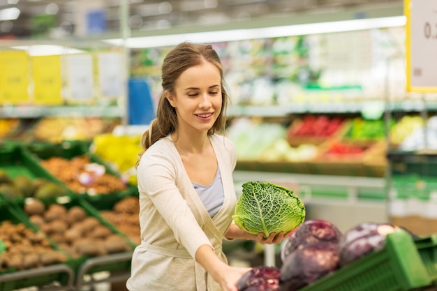 compras, comida, venta, consumismo y concepto de personas - mujer feliz comprando savoy en una tienda de comestibles o supermercado