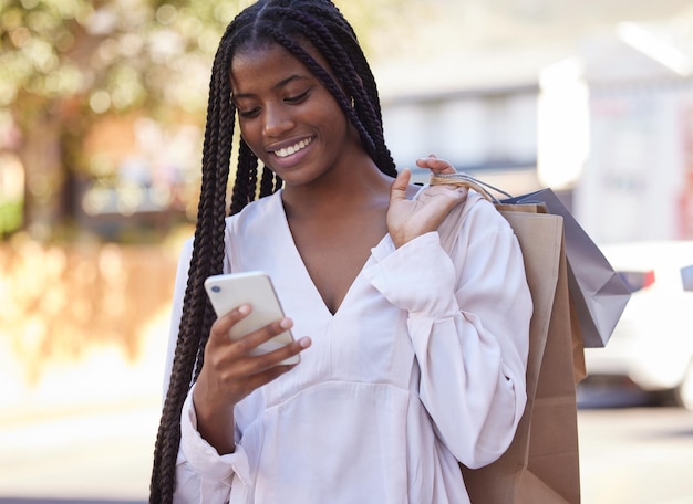 Compras de smartphone e moda mulher negra com desconto de venda ou promoção online para assinatura de site comércio eletrônico e varejo Saco de compras usando telefone e africano feliz com a escolha na cidade