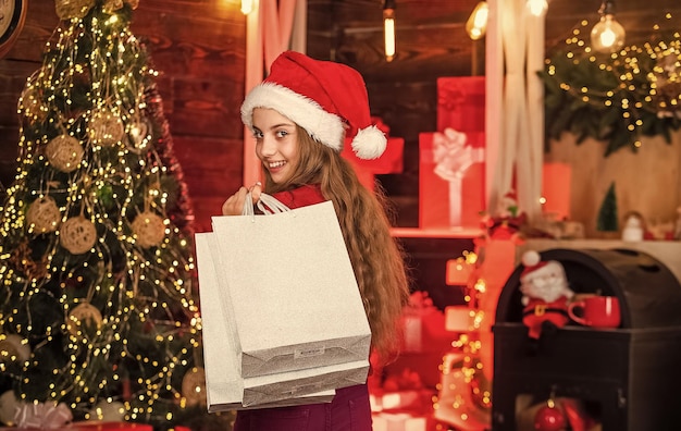 Compras divertidas para niños suéter de reno y sombrero de santa paquetes de compras para la familia pequeño niño adicto a las compras sonrisa con bolsas de papel compras de regalos navideños navidad está aquí año nuevo vacaciones de invierno