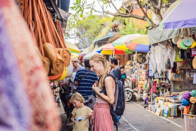 Compras em Bali. A jovem escolhe as famosas bolsas ecológicas de rattan balinesas em um mercado local de souvenirs em Bali, Indonésia