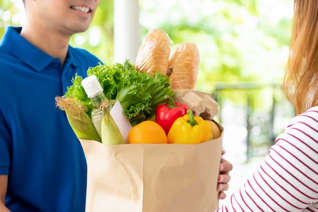 Compras entregues ao cliente em casa por um entregador, para o conceito de serviço de alimentação on-line