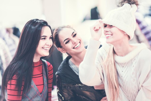 Compras Grupo de chicas felices probándose ropa en una boutique