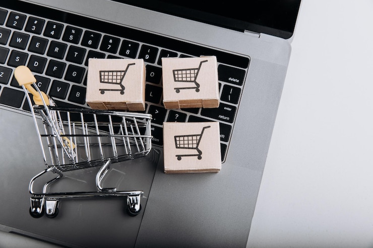 Foto compras en línea y concepto de entrega cajas de cartón con un carrito de compras en el teclado de la computadora portátil vista superior