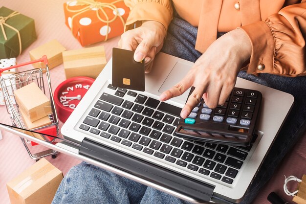 Compras en línea de Navidad Compradora femenina con portátil se preparan para la víspera de Navidad