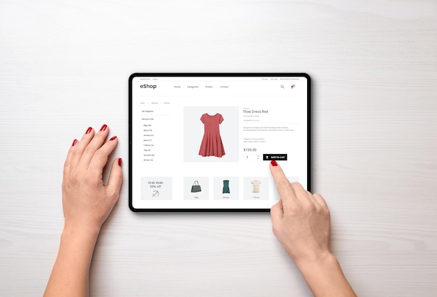 Compras en línea con una tableta Vestido rojo de mujer en la página web de comercio electrónico