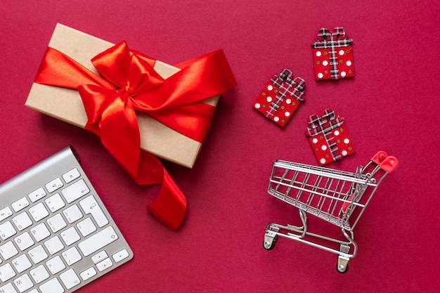 Compras en línea durante las vacaciones de Navidad. Hermoso regalo en carrito de compras comprado en Internet. Almacene en línea, usando una computadora. Concepto online de Navidad durante la cuarentena y el cierre