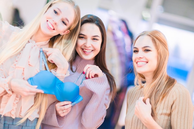 Compras Meninas alegres estão considerando roupas íntimas Humor brincalhão