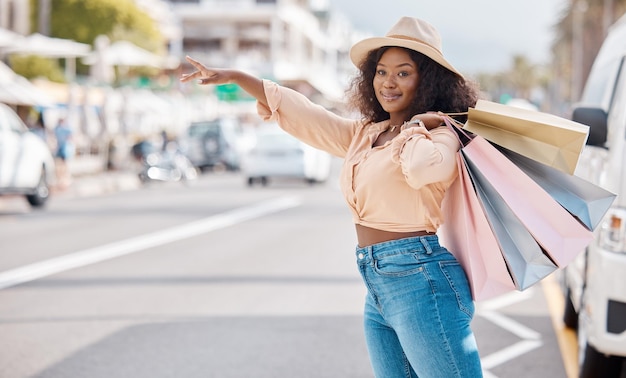 Compras minoristas y taxi con mujer negra en la ciudad para viajes de lujo y moda en la calle urbana Ventas felices y obsequios con el cliente y bolsa de descuento en la carretera para llamar al servicio de transporte en taxi