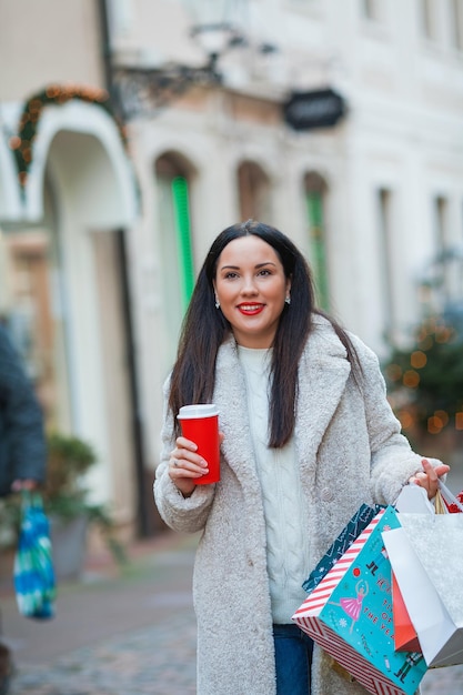 Compras navideñas Joven hermosa morena compra regalos para las vacaciones de Año Nuevo Vacaciones de invierno