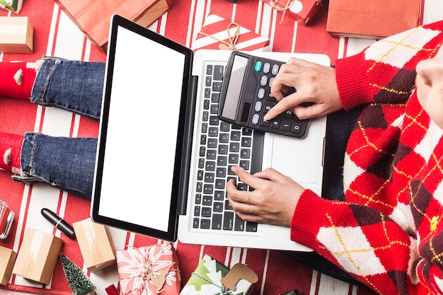 Compras navideñas online. Compradora femenina con laptop, prepárate para la víspera de Navidad,