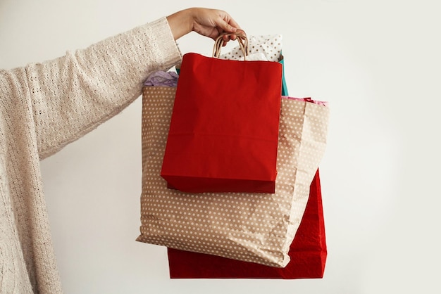 Foto compras navideñas y venta de temporada chica feliz con suéter sosteniendo bolsas de compras de papel rojo y verde centro comercial ventas navideñas espacio para texto viernes negro