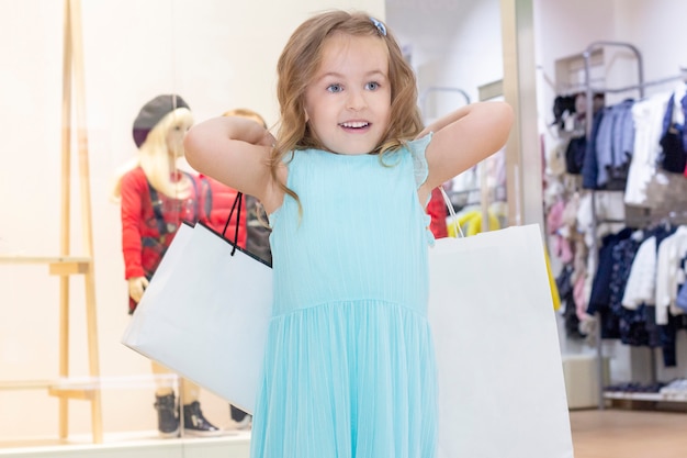 Compras. Una niña con bolsas en las manos.