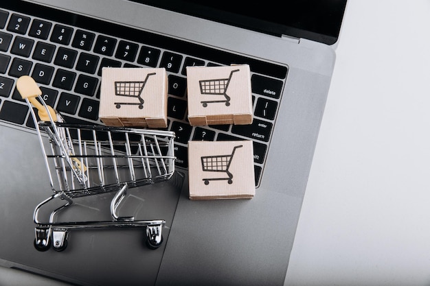 Compras on-line e conceito de entrega Caixas de papelão com um carrinho de compras no teclado do laptop Vista superior