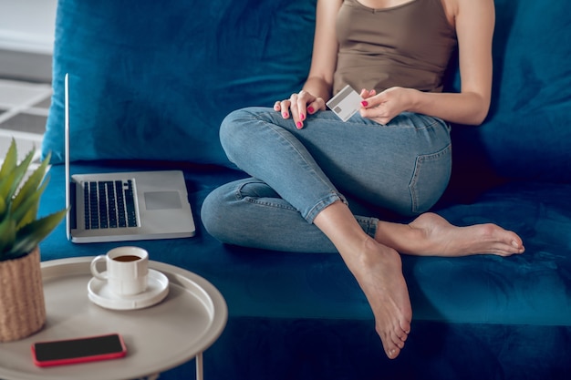 Compras online. Close-up de uma mulher sentada em um sofá com um laptop