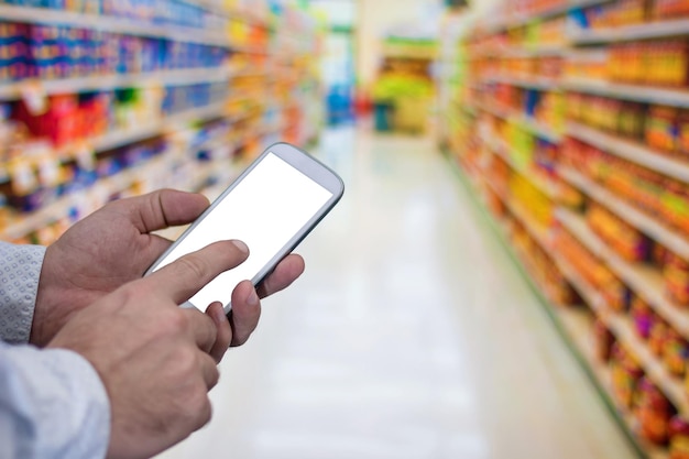 Compras con pantalla táctil en el teléfono móvil. Pago de telecomunicaciones de compra de pedidos por Internet. Hombre revisando la lista de compras en su teléfono inteligente en el supermercado.