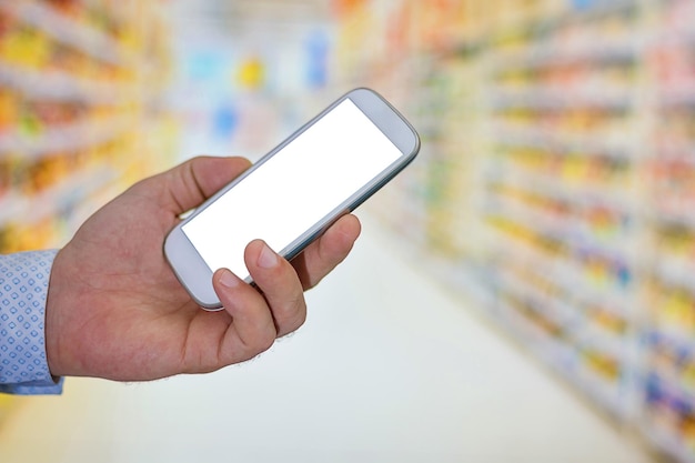 Compras con pantalla táctil en el teléfono móvil. Pedidos por Internet comprando pago de telecomunicaciones. Hombre revisando la lista de compras en su teléfono inteligente en el supermercado.