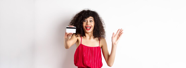 Foto compras surpreendeu a mulher de cabelos encaracolados em vestido vermelho mostrando cartão de crédito de plástico e gritos de excitadores