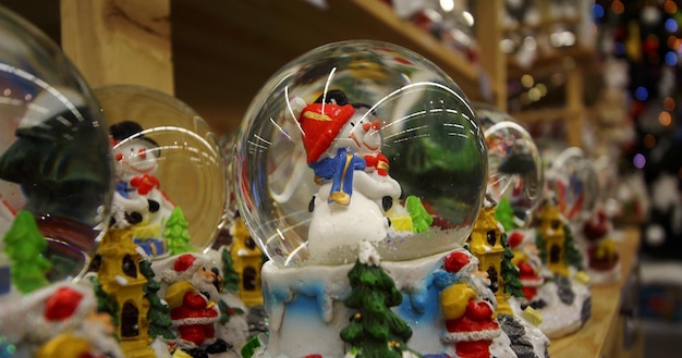 Compras de vacaciones. Bolas de nieve con muñecos de nieve en la tienda de decoraciones