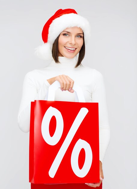 Foto compras, venta, regalos, navidad, concepto de navidad - mujer sonriente, en, santa, ayudante, sombrero, con, bolsas de compras