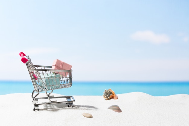 Compras de verano. Negocios y venta en la playa. Carro sobre arena blanca