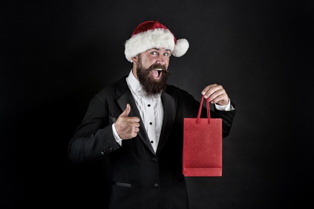 Compre una amplia gama de ropa elegante y funcional Servicios adicionales Ahorre en compras Compras con alegría Hombre barbudo sostiene bolsas de compras Compra regalos de año nuevo Compra de regalos Buena compra