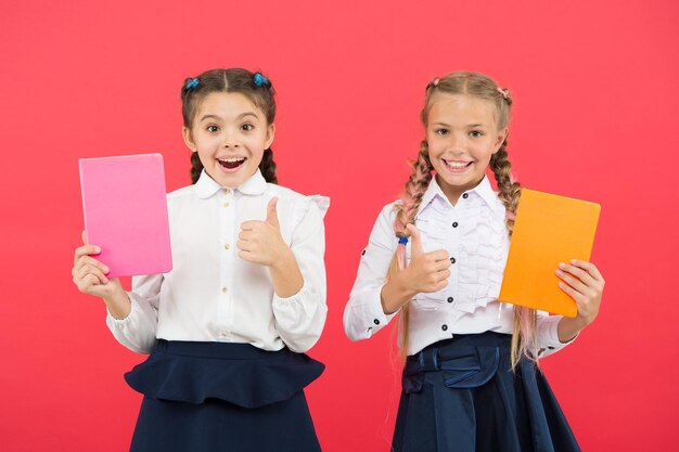 Compre artigos de papelaria fofos para se divertir estudando Meninas famosas pela obsessão com artigos de papelaria Meninas crianças uniforme escolar segure livro Colegial mostra diário bloco de notasConceito de material escolar Artigos de papelaria escolar