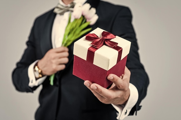 Compre en las tiendas ideas para regalos Caja de regalo en manos masculinas Tienda de regalos Arreglo floral Celebración festiva Ocasión festiva